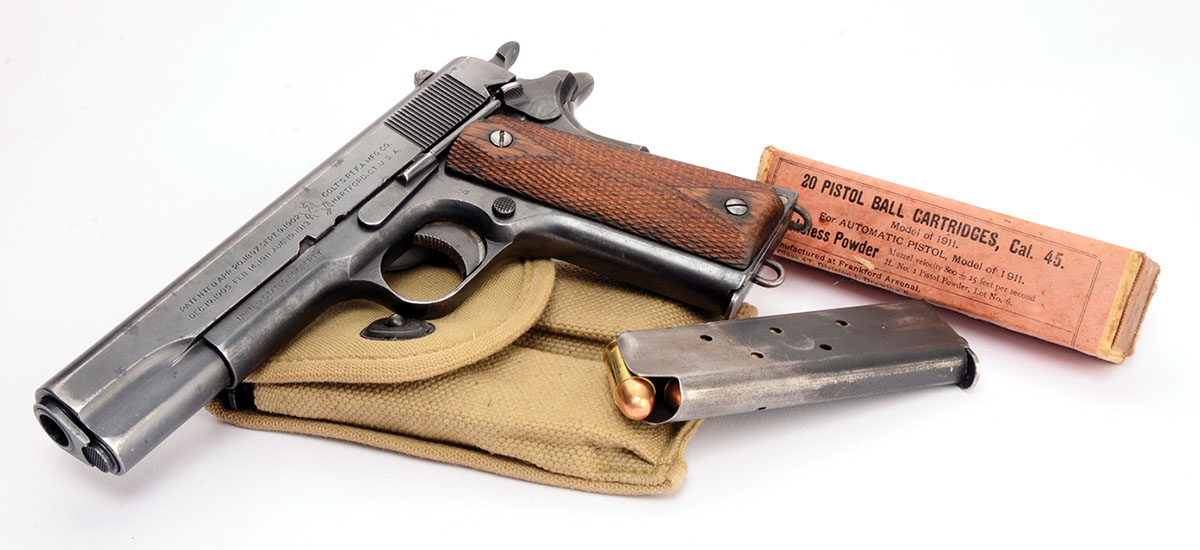 A Colt Model 1911 (vintage of 1918) shown with an original box of military loads. The fine print states 800 fps plus/minus 25 fps.